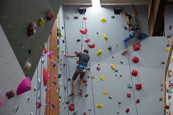 Two students climbing the WWU climbing wall.